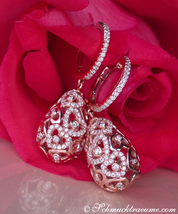 Herzformige Ohrringe aus Roségold mit Diamanten, auf Rosenblüte abgebildet