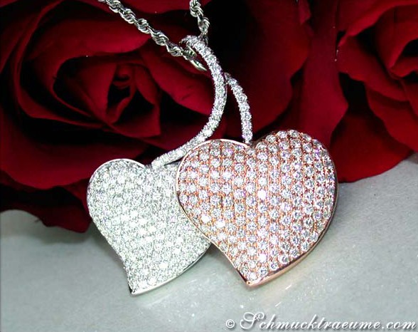 Herz-Anhänger aus Weißgold & Roségold mit Diamanten, vor rotem Rosenblütenhintergrund