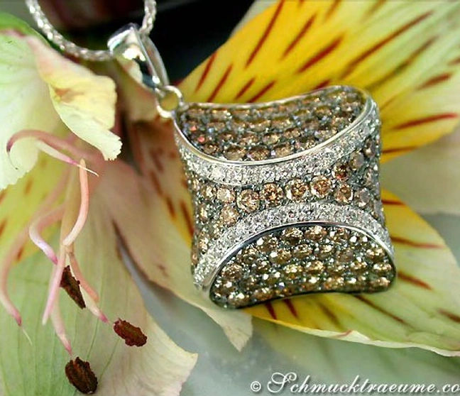 Goldener Anhänger mit naturbraunen und weißen Brillanten, detailreich, auf Blütenblatt getragen. Goldener Anhänger mit naturbraunen und weißen Brillanten, detailreich, auf Blütenblatt getragen.