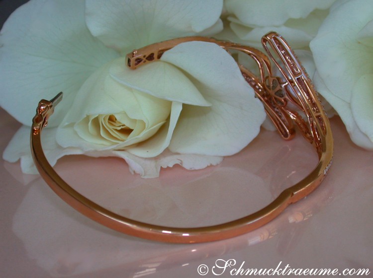 Weißes Rosenblütenblatt mit goldenem Armband im Hintergrund