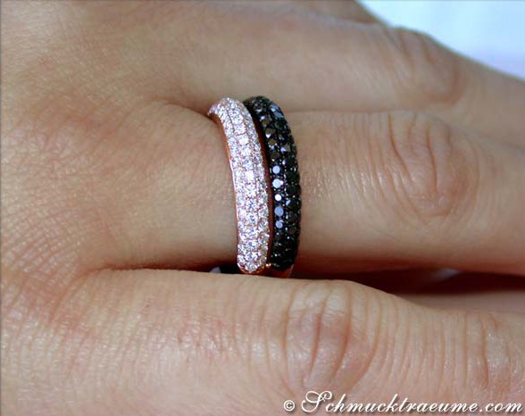 Roségold-Ring mit schwarzen und weißen Diamanten, Detailaufnahme auf Handfinger.