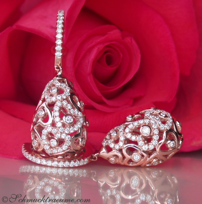 Herzformige Ohrringe aus Roségold mit Brillanten vor Rosenblüte