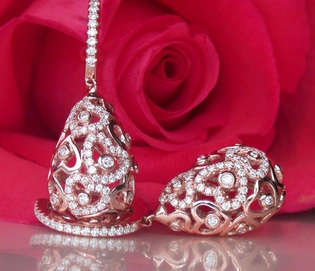 Herzformige Ohrringe aus Roségold mit Brillanten vor Rosenblüte