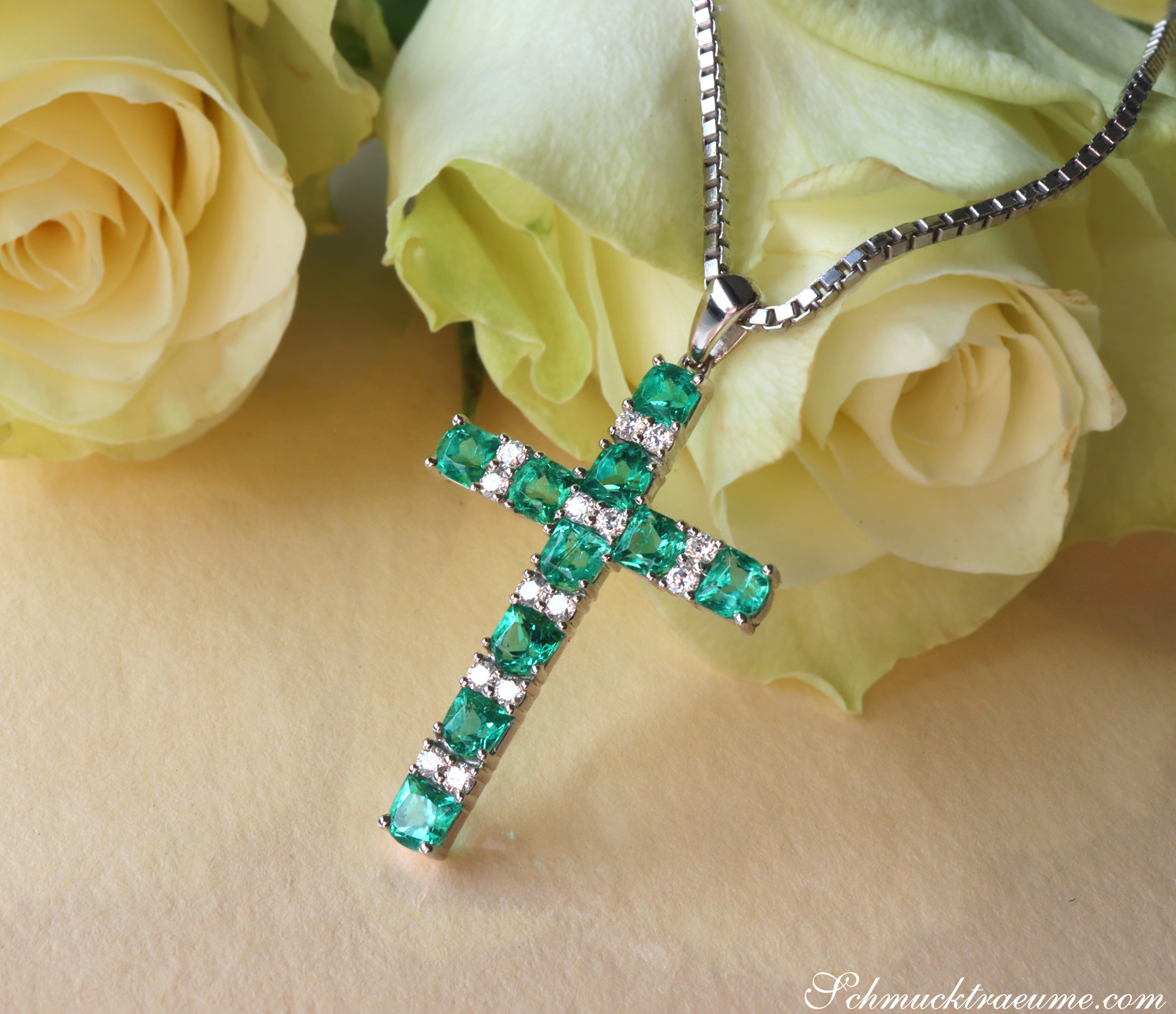 Smaragd Kreuz Anhänger mit Brillanten auf Rosenblättern, detailreich, elegant.
