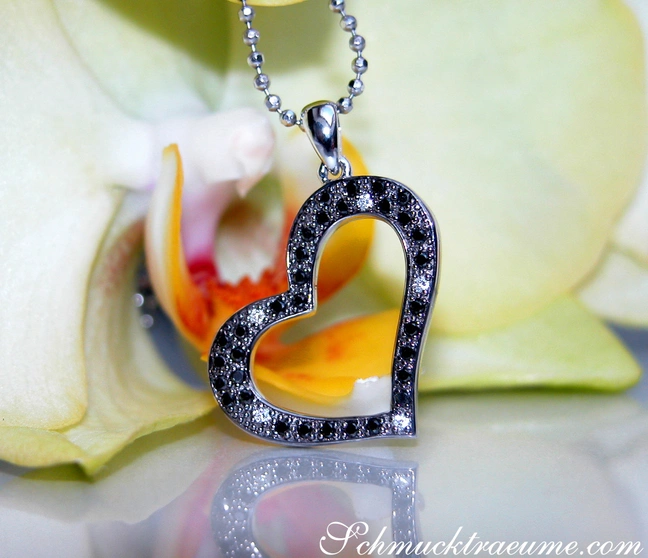 Weißgold Herz-Anhänger mit schwarzen Diamanten auf Orchideenblüte. Weißgold Herz-Anhänger mit schwarzen Diamanten auf Orchideenblüte.