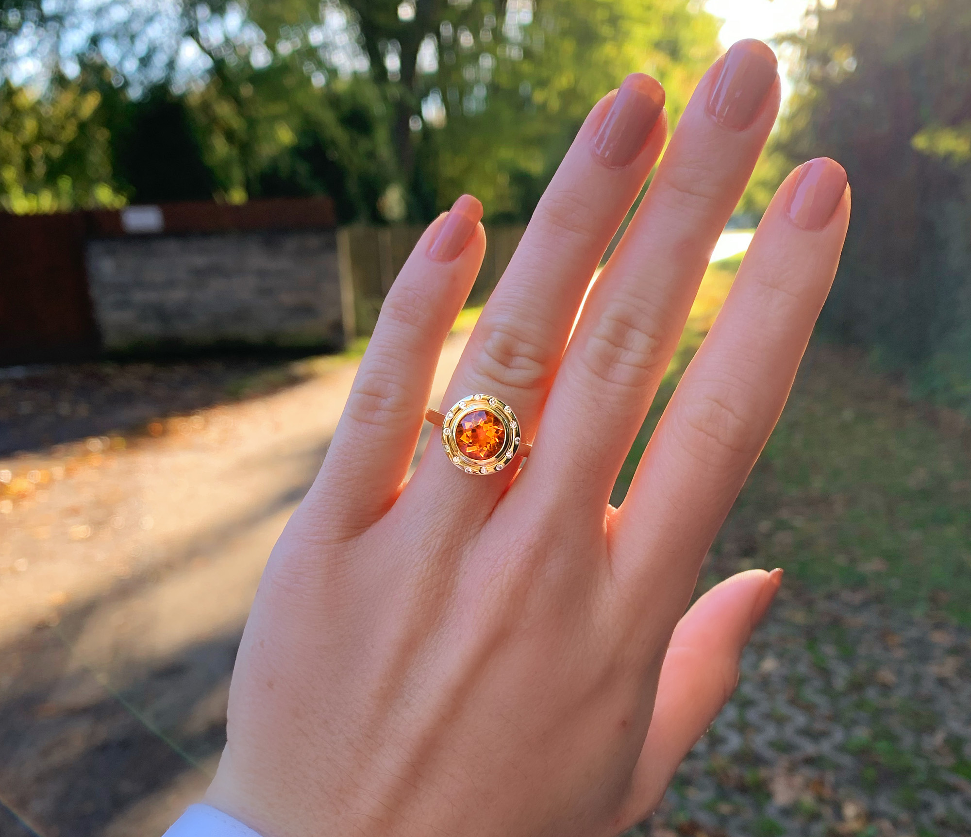 Goldener Citrin-Ring auf geöffneter Hand im Sonnenlicht