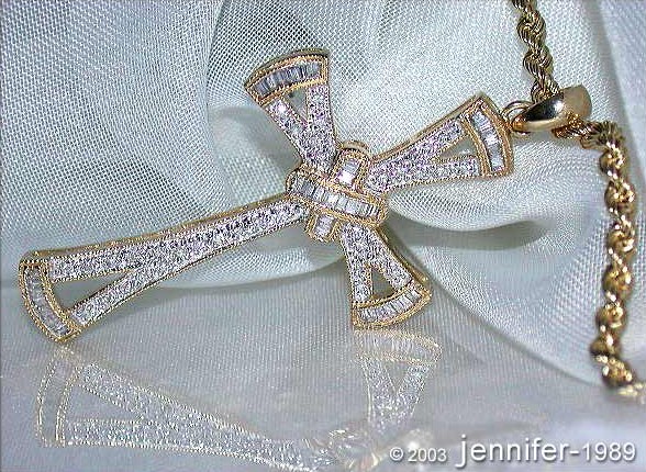 Goldener Diamantkreuzanhänger auf Seidenstoff, Detailaufnahme.