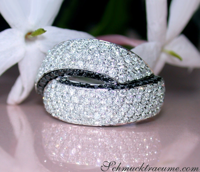 Klassischer Brillantenring mit schwarzen Diamanten, Detailaufnahme auf glänzender Oberfläche Klassischer Brillantenring mit schwarzen Diamanten, Detailaufnahme auf glänzender Oberfläche