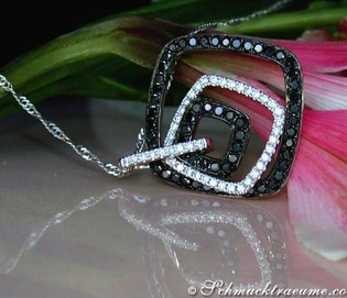 Schwarz-weißer Diamantanhänger auf Kette, Detailaufnahme vor Blume