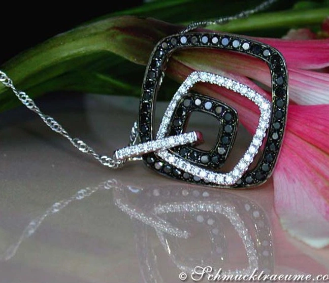 Schwarz-weißer Diamantanhänger auf Kette, Detailaufnahme vor Blume Schwarz-weißer Diamantanhänger auf Kette, Detailaufnahme vor Blume