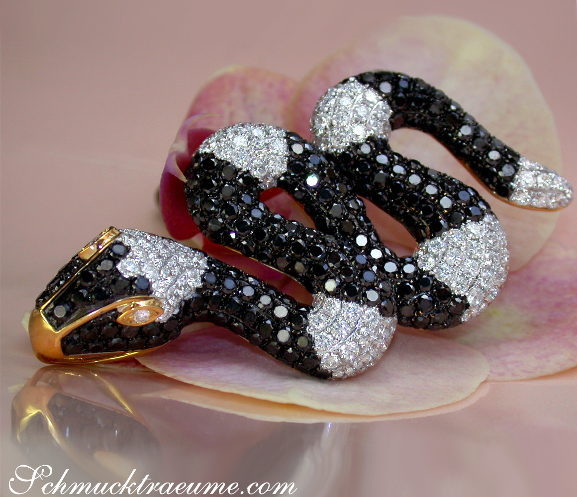 Schlangenanhänger mit schwarzen & weißen Diamanten auf Orchideenblüte.