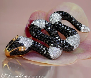 Schlangenanhänger mit schwarzen & weißen Diamanten auf Orchideenblüte.