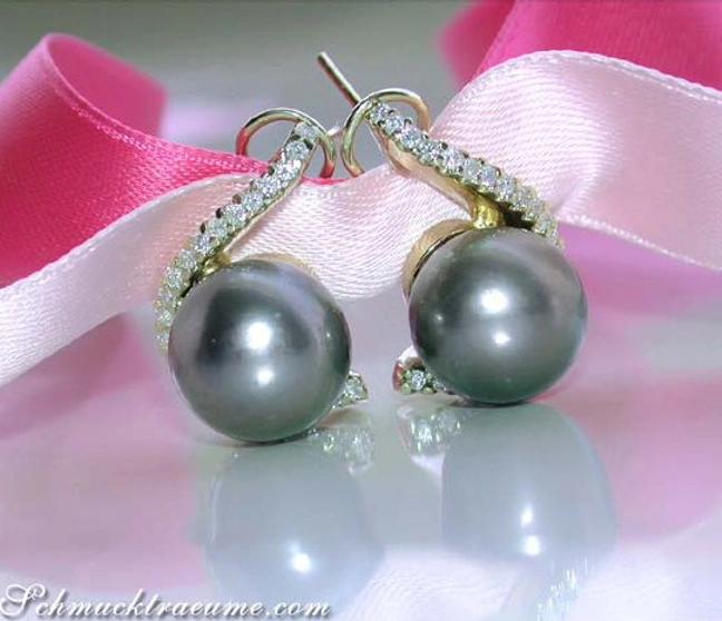 Gelbgold-Ohrstecker mit Tahitiperlen und Brillanten, elegant auf rosa Satin ausgelegt Gelbgold-Ohrstecker mit Tahitiperlen und Brillanten, elegant auf rosa Satin ausgelegt