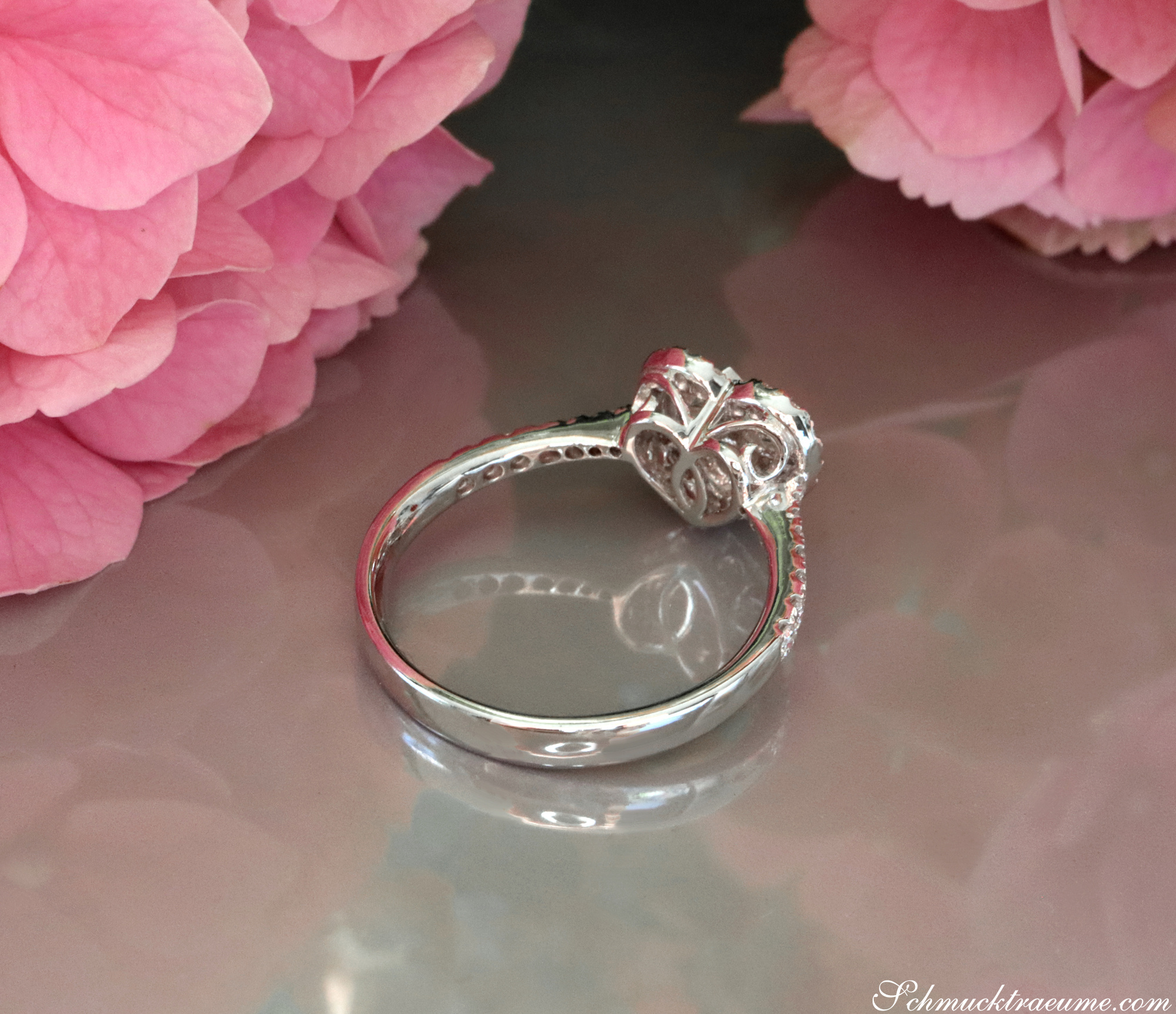 Silberner Herzring mit VS-Brillanten, detailreiches Design, Rosenblüten im Hintergrund