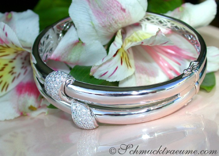 Weißgold-Armreif mit Diamant-Details, Blumen im Hintergrund, Detailaufnahme