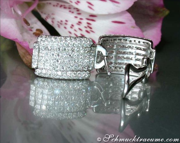 Weißgold Ohrstecker mit Diamanten, Detailaufnahme, zarte Fassung, Blumen im Hintergrund