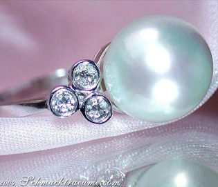 Perlenring mit Diamanten in Weißgold, elegant auf silberner Unterlage