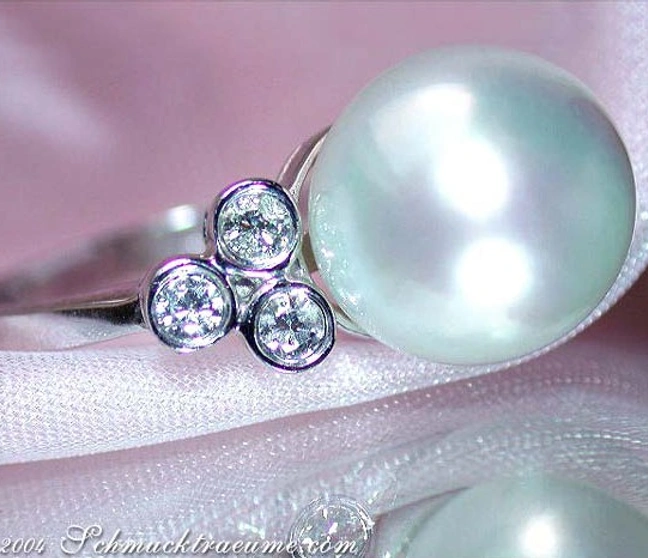 Perlenring mit Diamanten in Weißgold, elegant auf silberner Unterlage Perlenring mit Diamanten in Weißgold, elegant auf silberner Unterlage