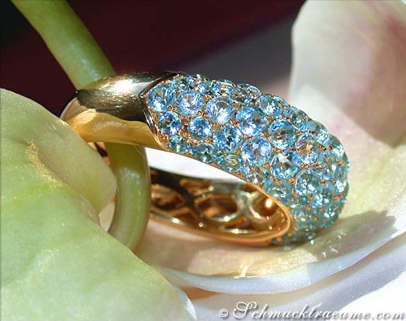 Detailansicht des Blautopas Pavé Rings, goldene Verarbeitung, glänzende Steine auf Blüte.