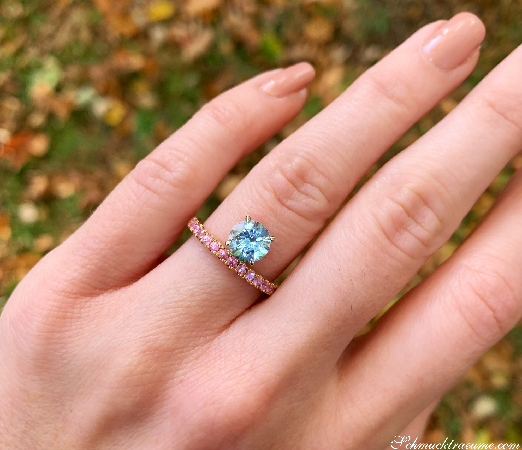 Raffinierter Aquamarin-Ring mit rosa Saphiren, Detailaufnahme auf Hand, im Freien