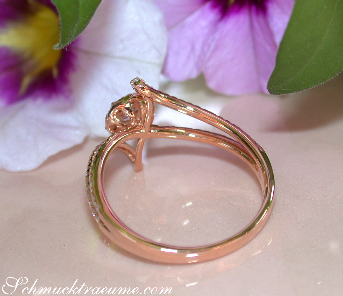 Mini Solitär-Ring aus Roségold mit Brillanten, Detailaufnahme mit Blume im Hintergrund