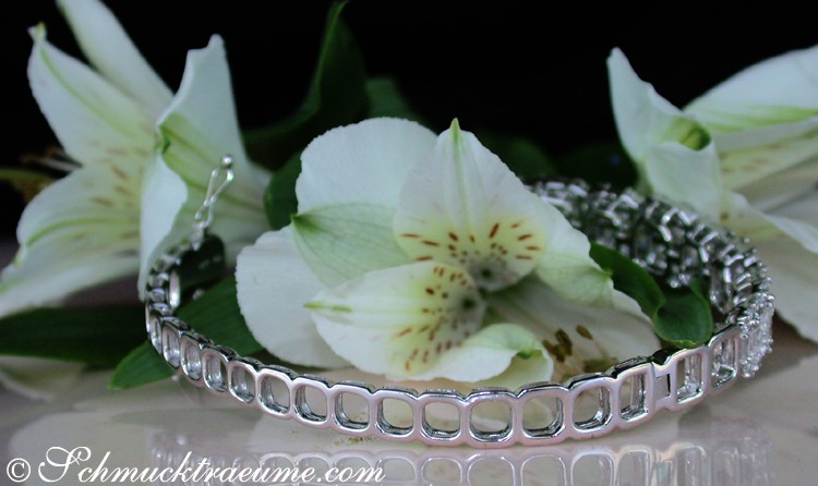 Silberner Armband mit Diamanten auf Blumenhintergrund