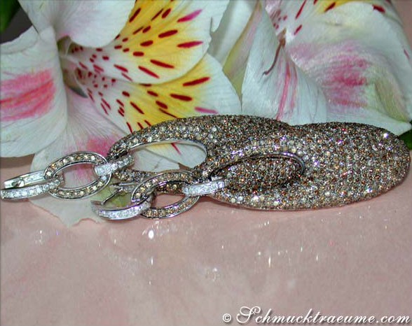 Detaillierter Blick auf luxuriöse Ohrgehänge mit braunen und weißen Brillanten, Weißgold 750, auf Blütenblatt platziert.