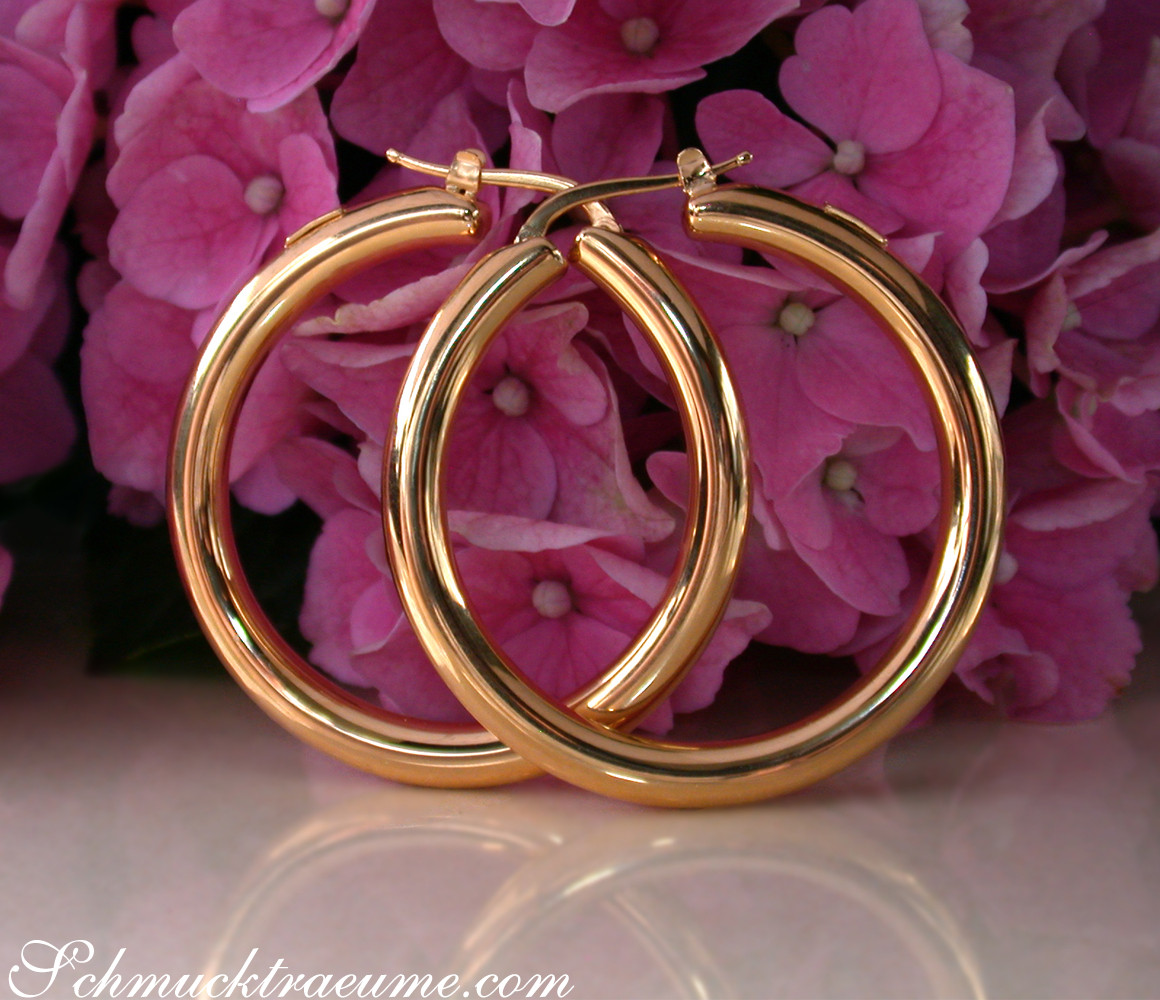 Gold Creolen in Gelbgold 585, 40 mm, vor rosa Hortensienblüten, Detailaufnahme.