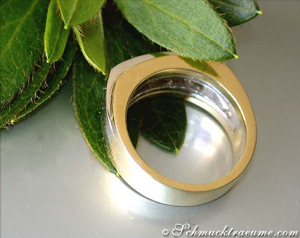 Goldener Ring mit Diamant vor grünen Blättern