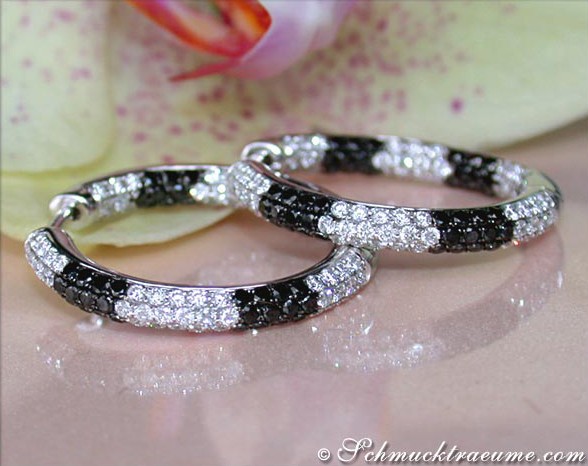 Schwarz-weiße Diamant-Creolen auf Blütenblatt, elegante Ohrschmuck-Pracht.