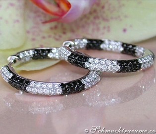 Schwarz-weiße Diamant-Creolen auf Blütenblatt, elegante Ohrschmuck-Pracht.