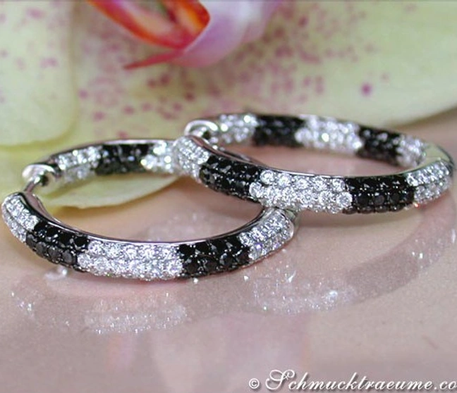 Schwarz-weiße Diamant-Creolen auf Blütenblatt, elegante Ohrschmuck-Pracht. Schwarz-weiße Diamant-Creolen auf Blütenblatt, elegante Ohrschmuck-Pracht.