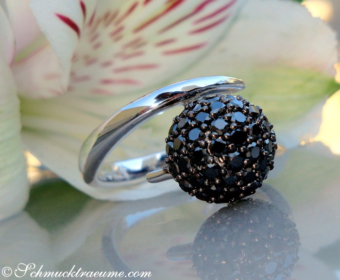 Detailansicht des schwarzen Diamanten Pavé Ringes, Weißgold 585, auf Blüte abgestellt.
