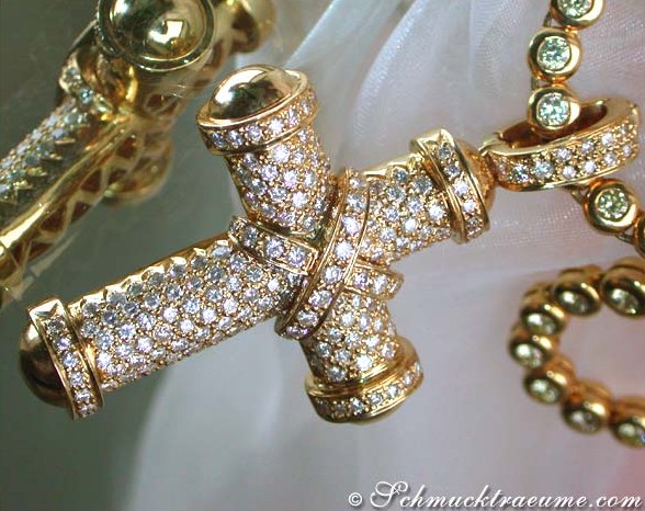 Goldener Kreuzanhänger mit Diamanten, Detailaufnahme, auf weißem Hintergrund.