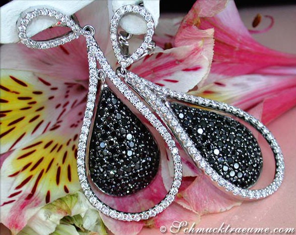 Schwarze und weiße Diamant-Ohrringe in Weißgold, Detailaufnahme, elegant getragen.