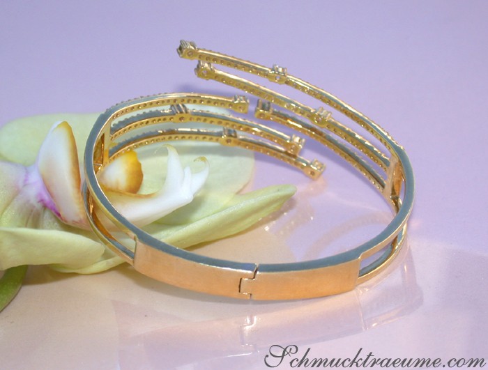 Goldene Armbänder mit Diamanten auf Orchideenblüte, Detailaufnahme.