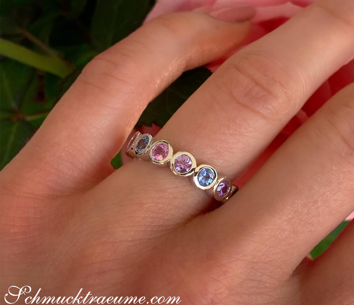 Weißgoldring mit Saphiren in Pastellfarben, Detailaufnahme auf Handfinger.