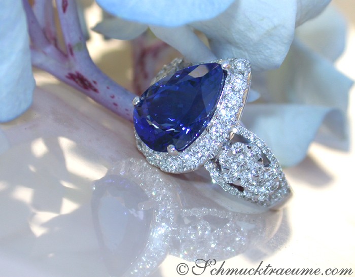 Weißgoldring mit Tansanit und Brillanten, blütenähnlicher Hintergrund