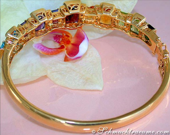 Goldener Edelstein-Armreif mit farbigen Steinen und Orchideenblüte