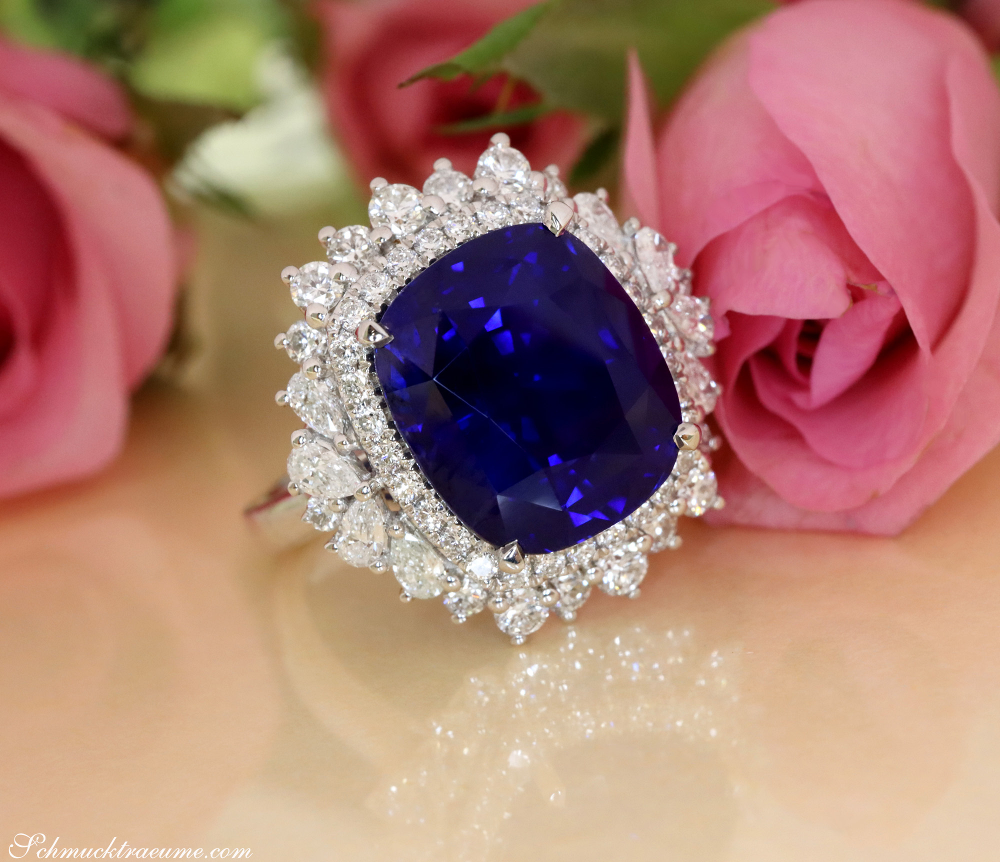 Blauer Ceylon-Saphir-Ring mit Diamant-Halo, Rosen im Hintergrund