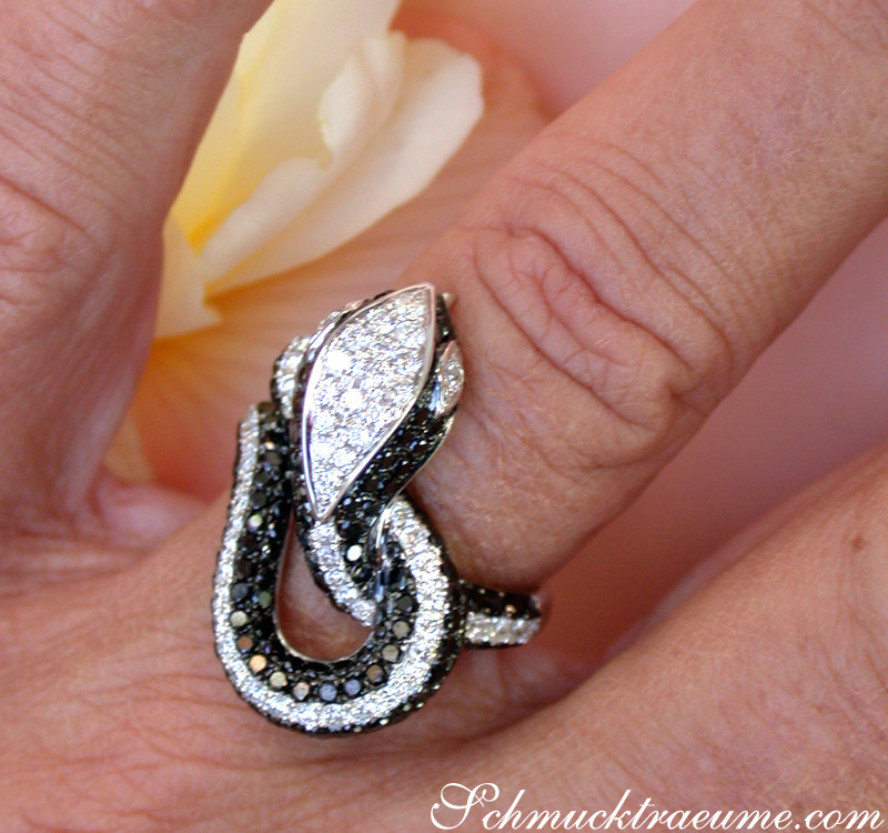 Schlangenring aus Weißgold mit schwarzen und weißen Diamanten, Detailaufnahme auf Hand