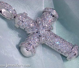 Weißgoldkreuzanhänger mit Diamanten, detailreich, auf blauem Stoff liegend