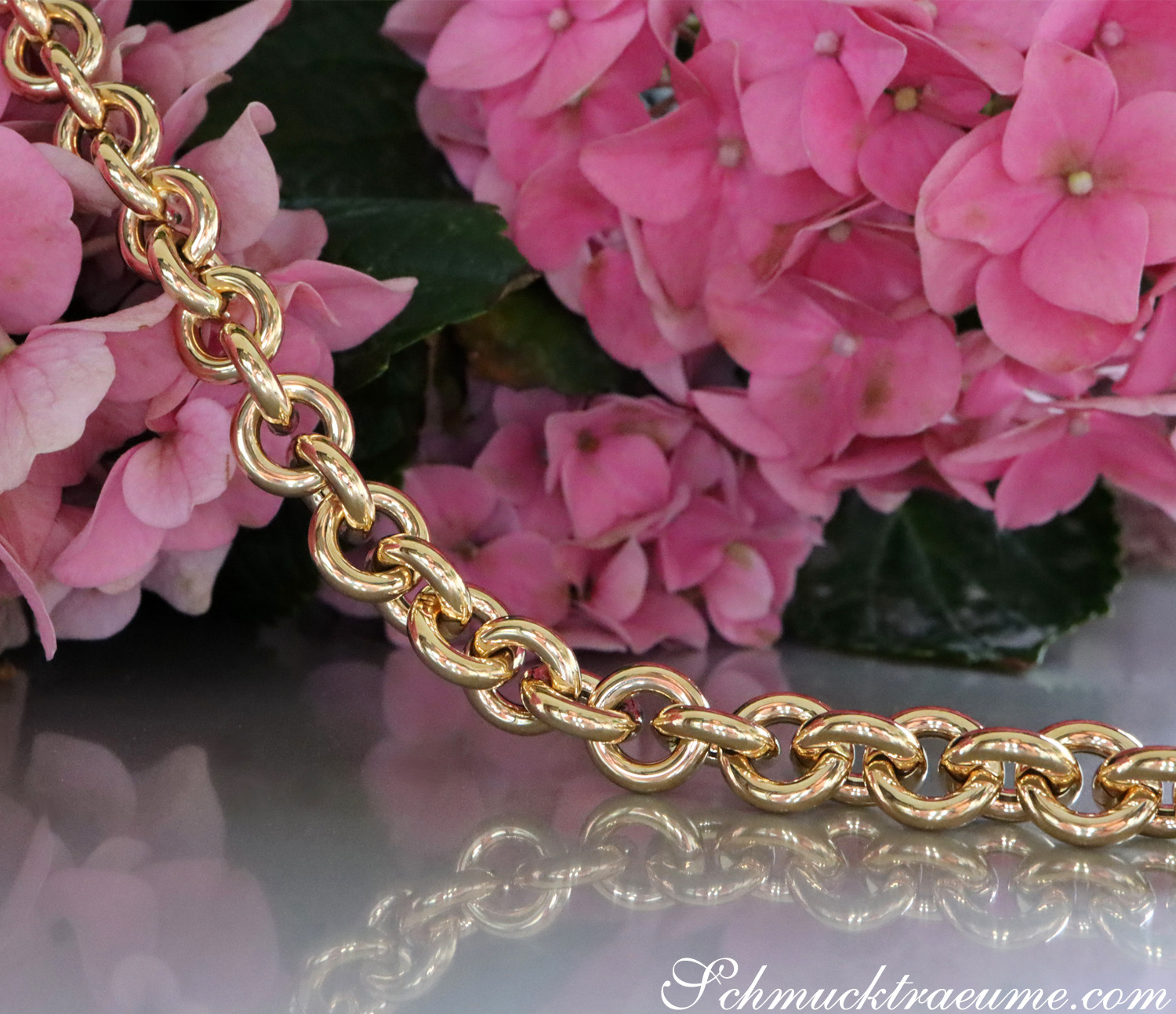 Goldene Gliederkette auf Blütenhintergrund