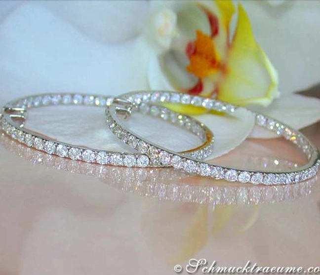 Weißgold Creolen mit 8.77 ct. Brillanten, Detailaufnahme, Orchidee im Hintergrund Weißgold Creolen mit 8.77 ct. Brillanten, Detailaufnahme, Orchidee im Hintergrund