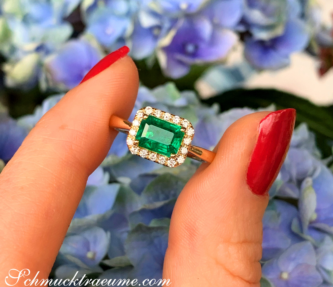 Smaragd-Ring mit Brillanten in Gelbgold 585, Detailaufnahme, blauer Hintergrund.