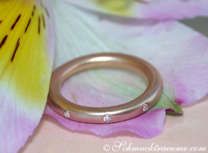 Roségold-Ring mit Diamanten im Sternenhimmel-Design auf Blüte liegend