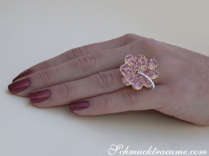 Finger mit rosa Saphir-Blütenring, Nagellack dunkelrot, Detailaufnahme