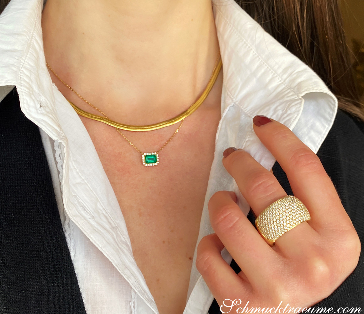 Goldene Halskette mit Smaragd und Brillanten, Detailaufnahme, elegant getragen.