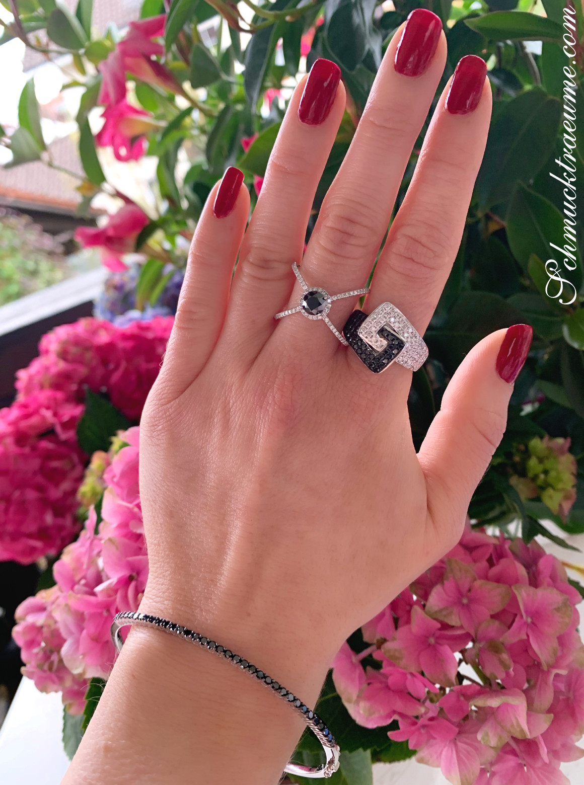 Schwarzer Diamant Solitär-Ring, moderner Chic, Nagellack rot, Hintergrund Blumen.