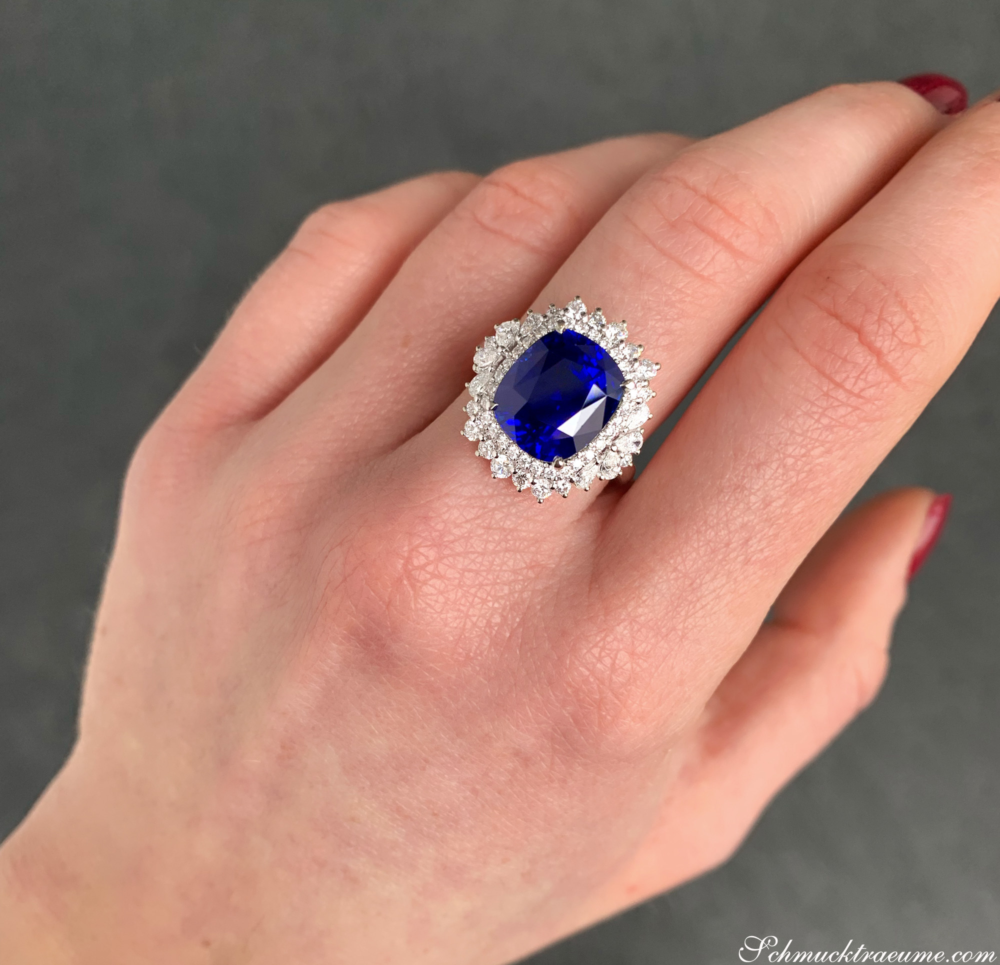 Weißgold-Ring mit ovalen Ceylon-Saphir und Diamanten, Detailansicht auf Handfinger.